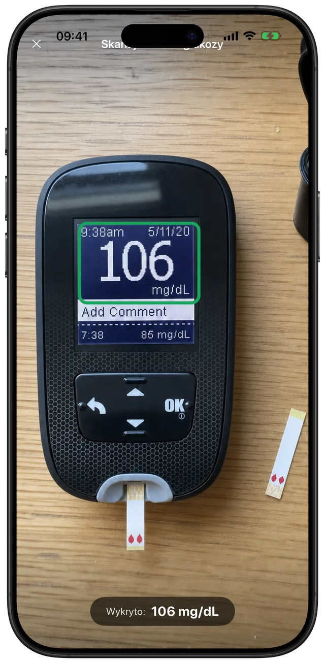 Skaner Gludiary wycelowany w glukometr, automatycznie wykrywający i przechwytujący odczyt 106 mg/dL z wyświetlacza urządzenia